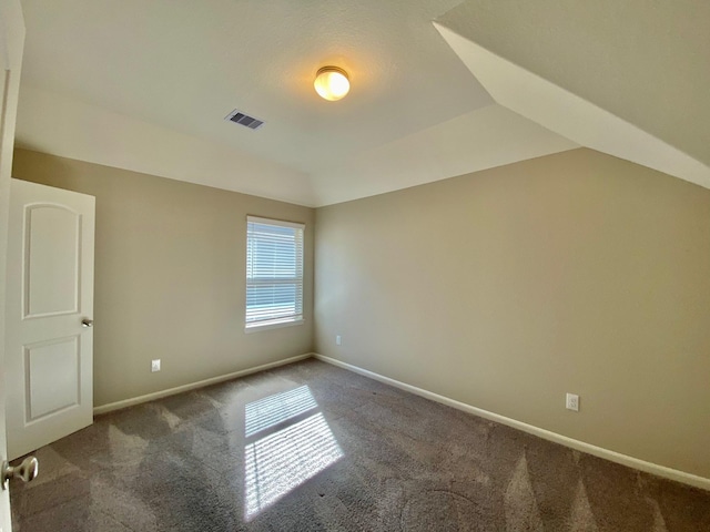 unfurnished room with carpet floors, lofted ceiling, visible vents, and baseboards