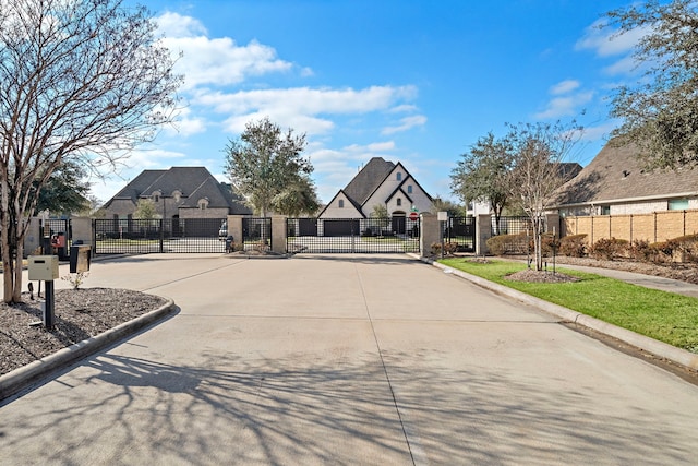 view of road with a residential view, a gate, curbs, and a gated entry