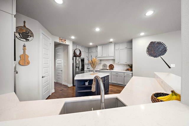 kitchen featuring recessed lighting, dark wood-style flooring, a sink, light countertops, and appliances with stainless steel finishes