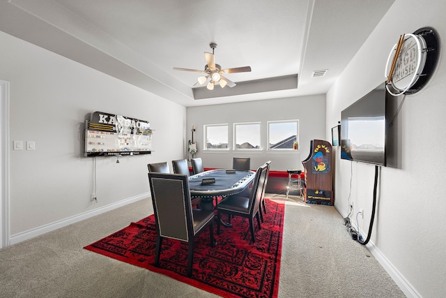 dining area featuring carpet floors, a raised ceiling, visible vents, ceiling fan, and baseboards