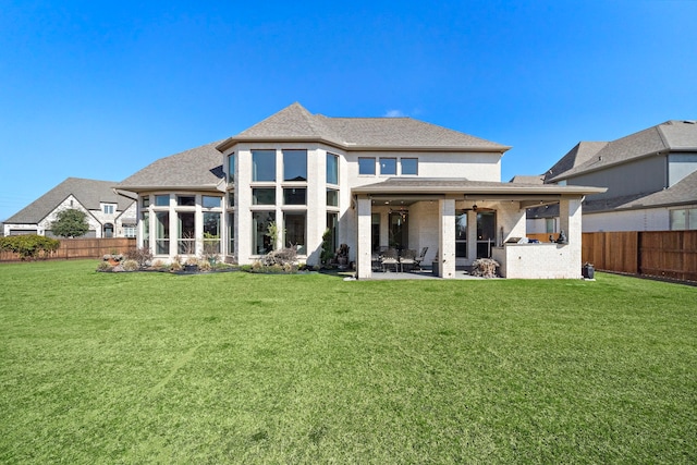 back of property with a fenced backyard, a sunroom, a ceiling fan, a lawn, and a patio area