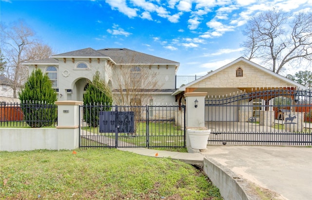 view of front facade with driveway, a fenced front yard, a front yard, and a gate