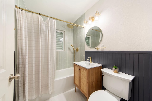 full bath featuring toilet, wainscoting, shower / bath combo with shower curtain, and vanity