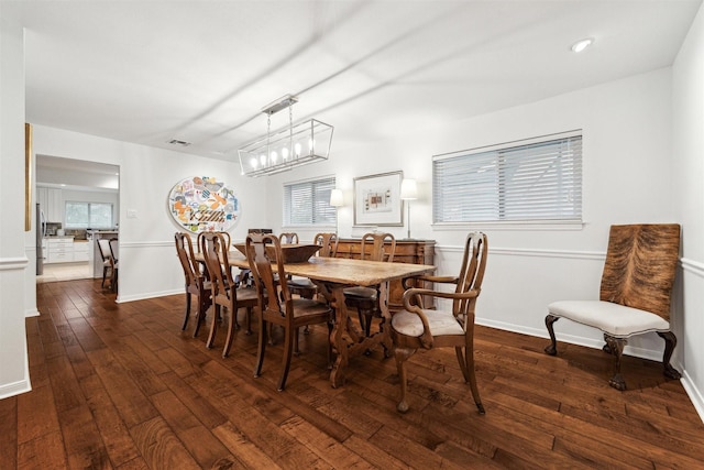 dining area featuring baseboards, visible vents, and dark wood-type flooring