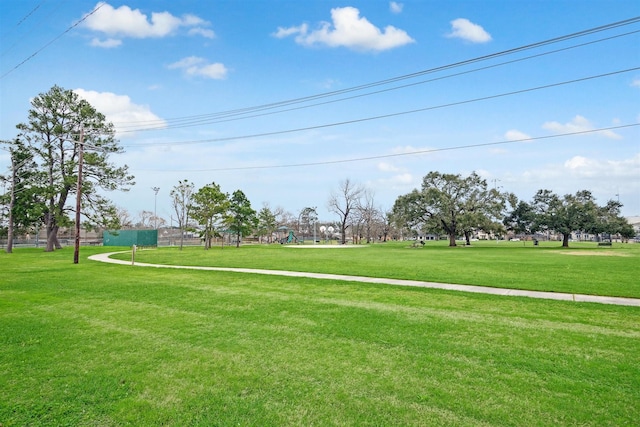 view of property's community featuring playground community and a yard