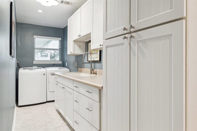 clothes washing area featuring cabinet space, visible vents, independent washer and dryer, a sink, and light tile patterned flooring