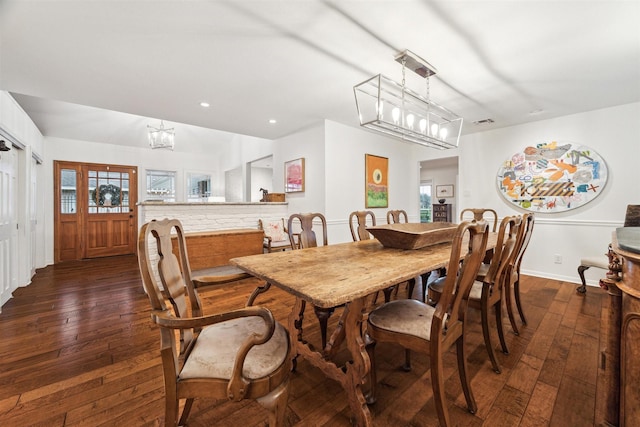 dining space featuring dark wood-type flooring, recessed lighting, visible vents, and a notable chandelier