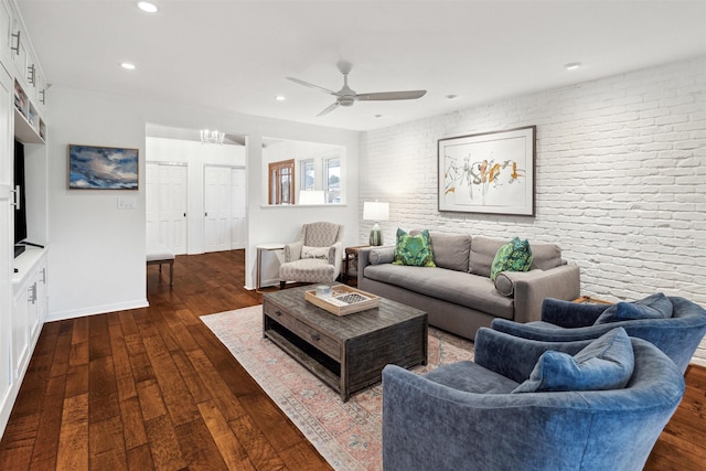 living room featuring baseboards, brick wall, ceiling fan, dark wood-type flooring, and recessed lighting