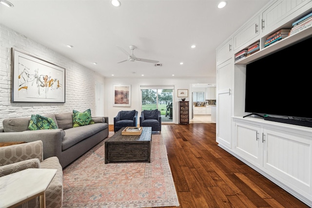 living room featuring brick wall, dark wood finished floors, a ceiling fan, and recessed lighting