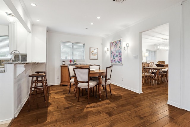 dining room featuring baseboards, dark wood-type flooring, recessed lighting, and crown molding