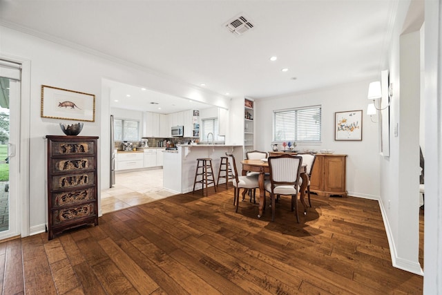 dining space featuring recessed lighting, visible vents, ornamental molding, light wood-type flooring, and baseboards