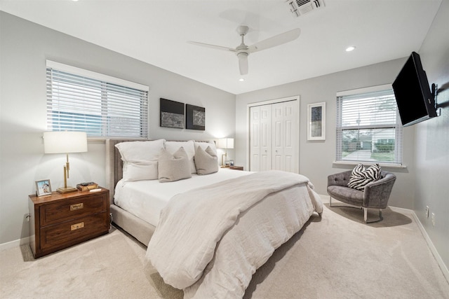 bedroom featuring a closet, visible vents, light carpet, ceiling fan, and baseboards