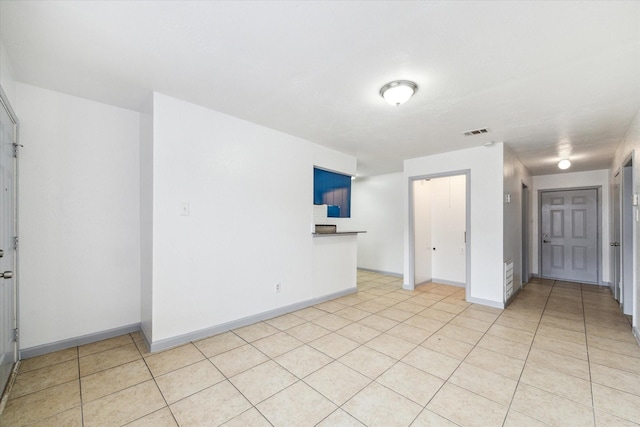 empty room with visible vents, baseboards, and light tile patterned flooring