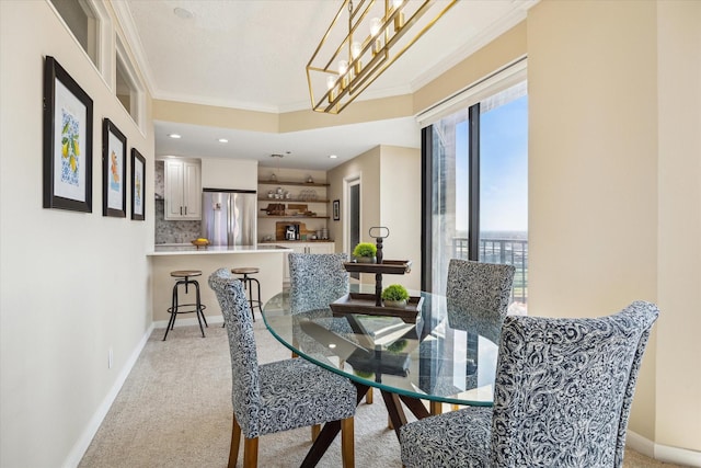 dining room with light carpet, baseboards, and crown molding