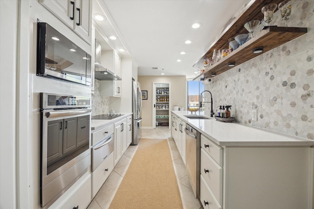 kitchen featuring stainless steel appliances, light countertops, and white cabinetry