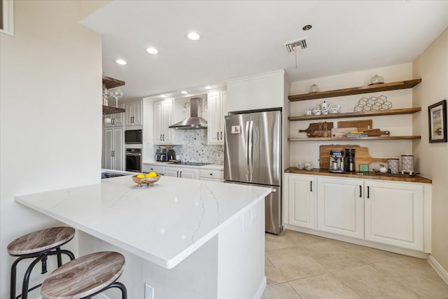 kitchen featuring wall oven, white cabinets, wall chimney exhaust hood, freestanding refrigerator, and built in microwave