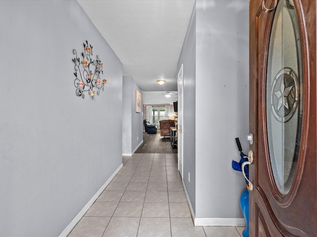 hall with baseboards and light tile patterned floors