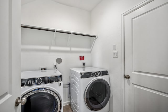 laundry room with laundry area, separate washer and dryer, and wood finished floors