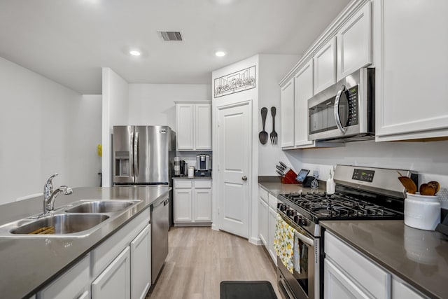 kitchen featuring dark countertops, visible vents, appliances with stainless steel finishes, and white cabinets