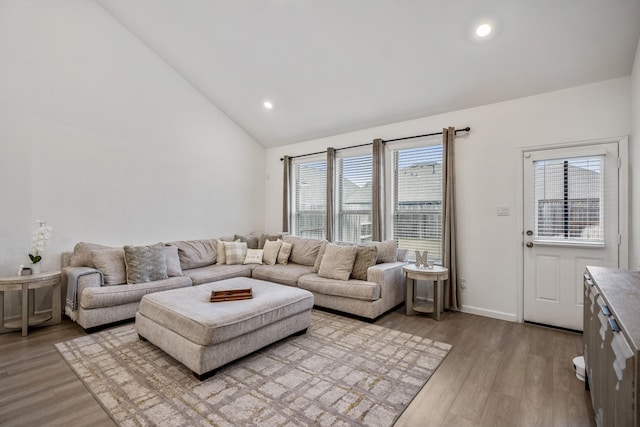 living room with baseboards, high vaulted ceiling, light wood-type flooring, and recessed lighting