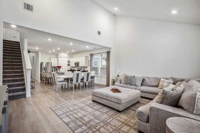 living area featuring stairs, recessed lighting, visible vents, and light wood-style floors