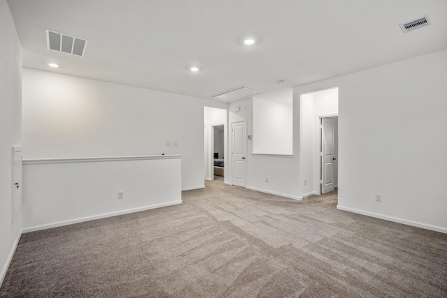 carpeted empty room featuring attic access, recessed lighting, and visible vents