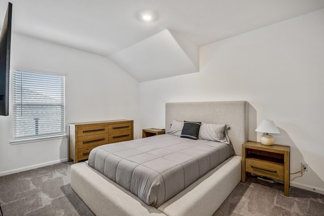 bedroom with lofted ceiling, dark carpet, and baseboards