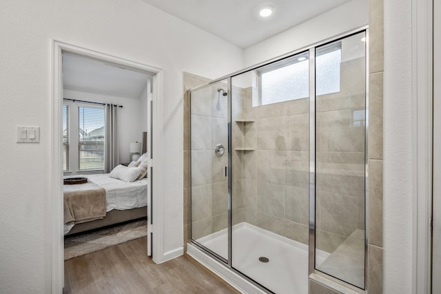 full bathroom featuring a shower stall, ensuite bath, and wood finished floors