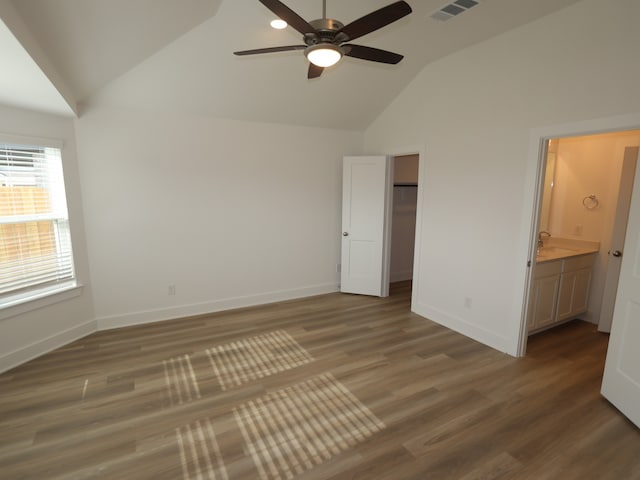 8022 Kay Harbor Dr, Cypress, TX 77433 - unfurnished bedroom featuring baseboards, wood finished floors, ensuite bathroom, high vaulted ceiling, and a walk in closet