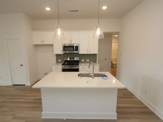 8022 Kay Harbor Dr, Cypress, TX 77433 - kitchen with stainless steel appliances, a sink, white cabinetry, decorative backsplash, and baseboards