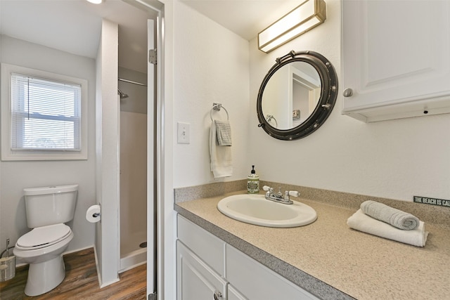 full bath featuring toilet, a shower stall, vanity, and wood finished floors