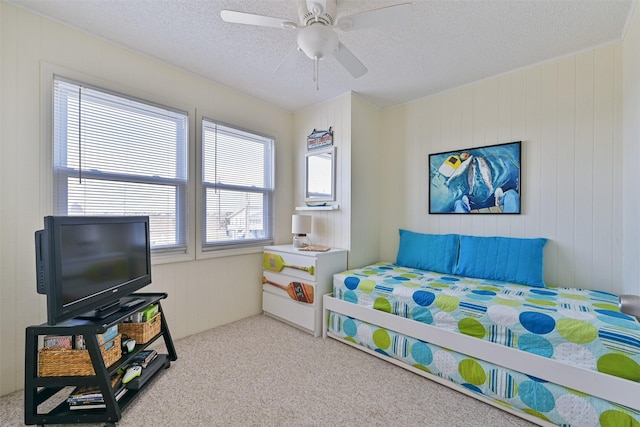 bedroom with a ceiling fan, light colored carpet, and a textured ceiling