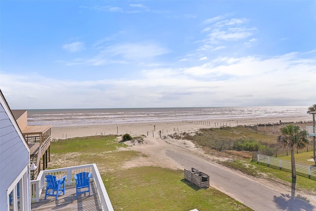 water view featuring fence and a beach view