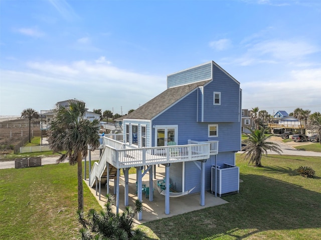 back of house featuring a shingled roof, central AC unit, a deck, a yard, and a patio area