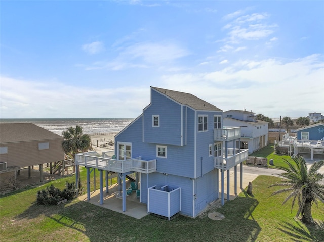 rear view of house featuring a lawn and a balcony