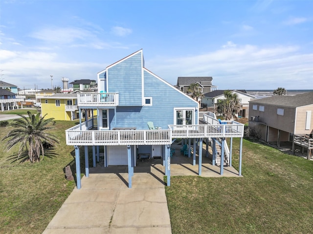 rear view of house featuring driveway, a balcony, a residential view, an attached garage, and a yard