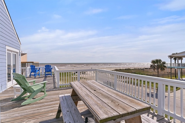 wooden terrace with a water view and outdoor dining area