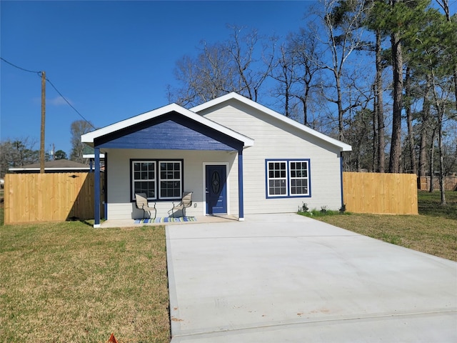 view of front of property featuring covered porch, fence, and a front yard