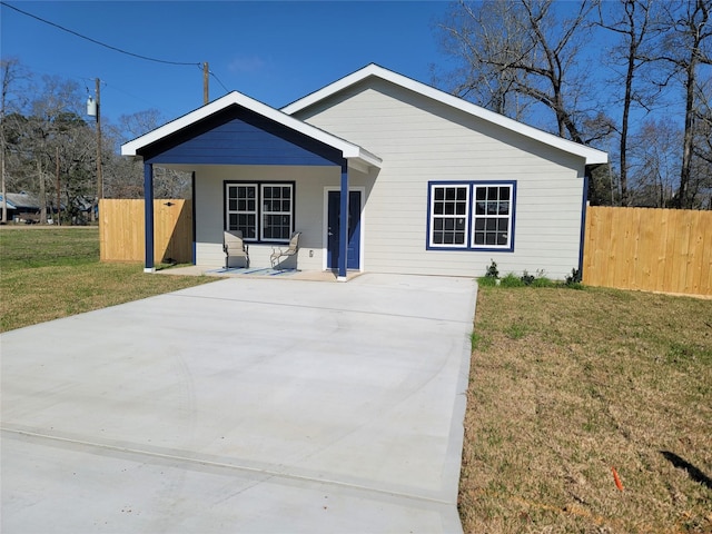 view of front of home with a porch, a front yard, and fence