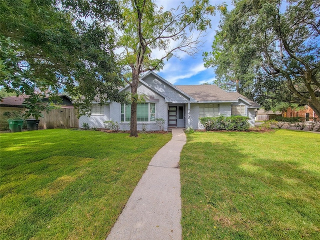 ranch-style house with brick siding, a front lawn, and fence