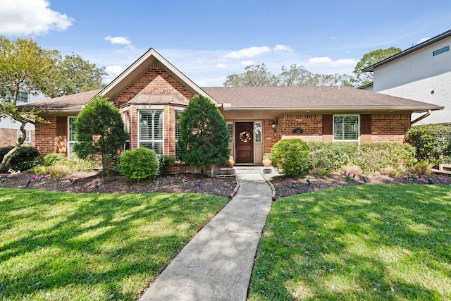 single story home featuring brick siding, a front lawn, and a shingled roof