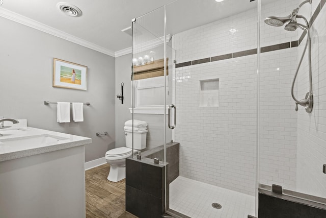 bathroom with visible vents, toilet, wood finished floors, crown molding, and vanity