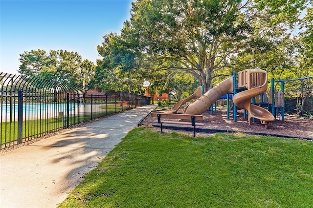 community playground featuring a yard and fence