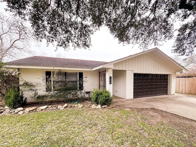 ranch-style home with a front lawn, concrete driveway, brick siding, and an attached garage