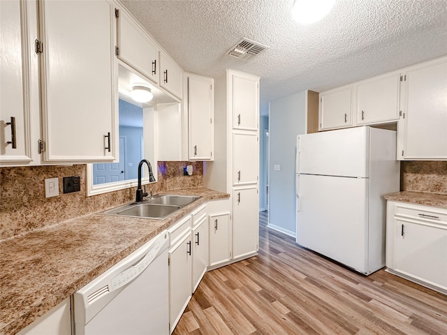 kitchen featuring light countertops, white appliances, a sink, and white cabinetry