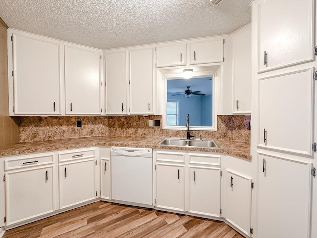 kitchen with dishwasher, light countertops, a sink, and white cabinetry