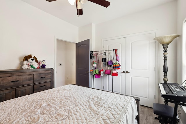 bedroom with ceiling fan, light wood finished floors, and a closet