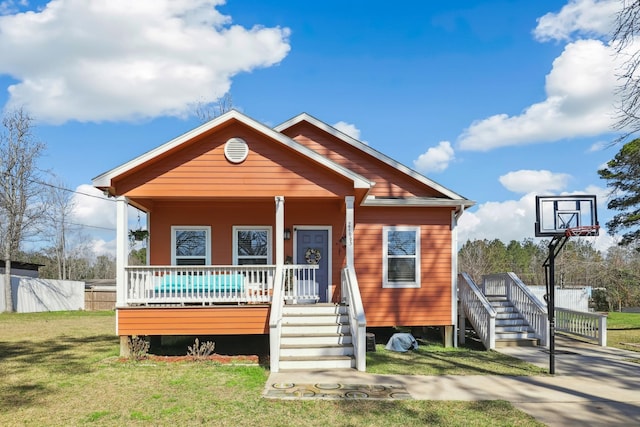 view of front facade with covered porch, fence, and a front lawn