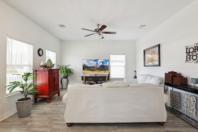 living area featuring plenty of natural light, visible vents, and wood finished floors