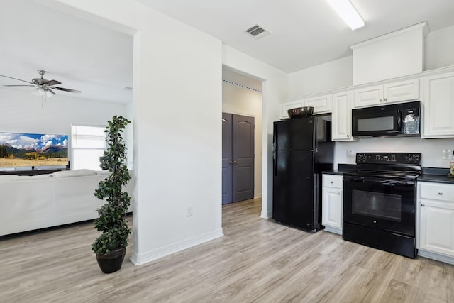 kitchen with dark countertops, black appliances, visible vents, and white cabinetry